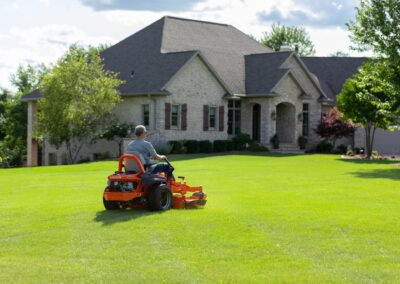A man riding a lawn mower in a yard
