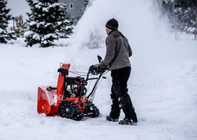 A man using a snow blower to clear snow